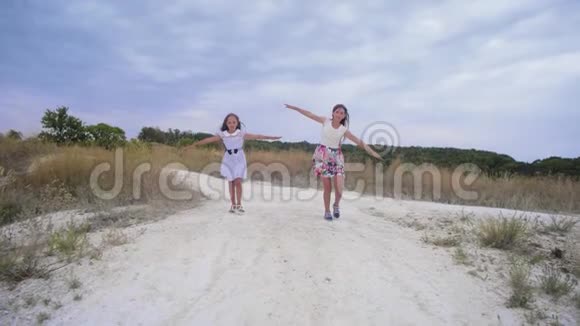 少女们沿着马路奔跑像翅膀一样张开双臂慢动作视频的预览图