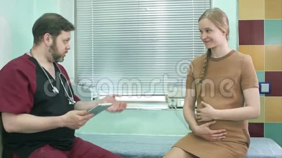 医生与孕妇交谈看着数码平板电脑视频的预览图