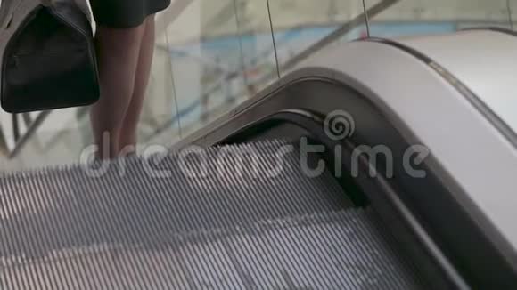 商务小姐手里拿着一个包坐在自动扶梯上视频的预览图