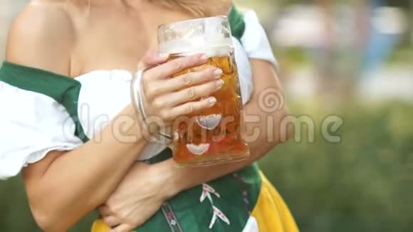 一杯巴伐利亚啤酒在一位身着国服的年轻女服务员手中音乐和啤酒节视频的预览图