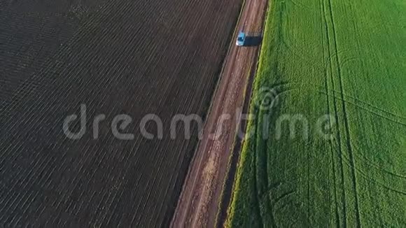 这辆车在乡间小路上行驶绿色麦田四旋翼拍摄视频的预览图