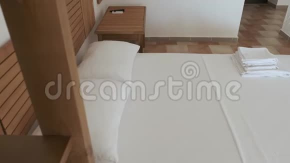 一张舒适的双人床站在酒店房间的瓷砖地板上视频的预览图