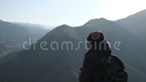 带相机拍摄高山照片的旅行者视频的预览图