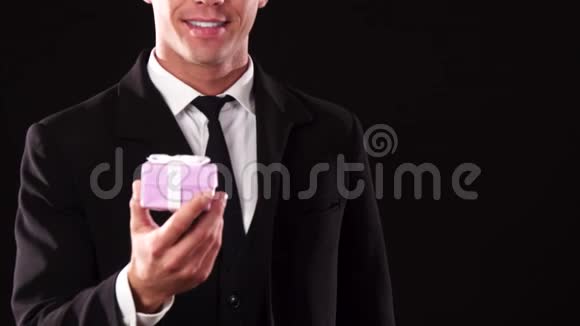 一个男人用一个小礼盒伸出手的特写视频的预览图