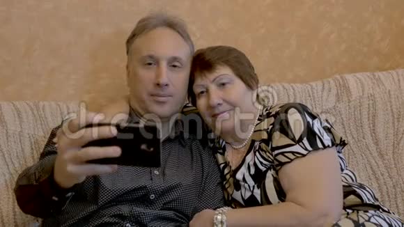 一位老妇人和她成年的儿子在智能手机上被拍照视频的预览图