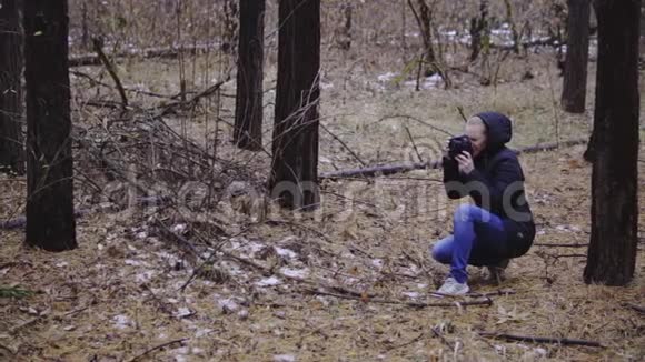 女孩在森林里拍摄秋天的风景深秋第一场雪同步射击视频的预览图
