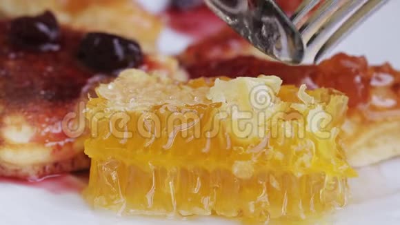 板上蜂窝的特写甜食用刀叉吃蜂窝做甜点视频的预览图