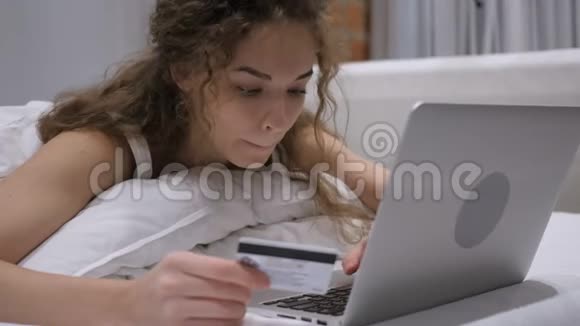 在床上使用银行卡在机付款的女性视频的预览图