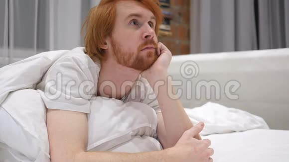 思考红头发的胡子男在床上放松头脑风暴视频的预览图