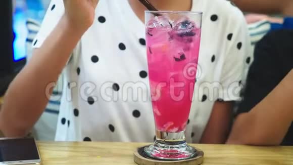 特写镜头咖啡馆里的女孩用吸管喝鸡尾酒饮料人和生活方式视频的预览图