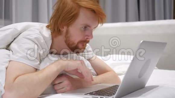 红头发胡子男人对项目失败的反应在笔记本电脑上观看视频的预览图