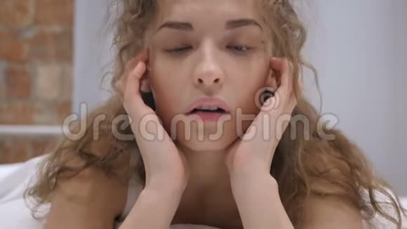 躺在床上有压力和头痛的美丽年轻女性视频的预览图