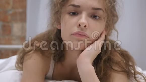 躺在床上悲伤不安的年轻女性脸视频的预览图