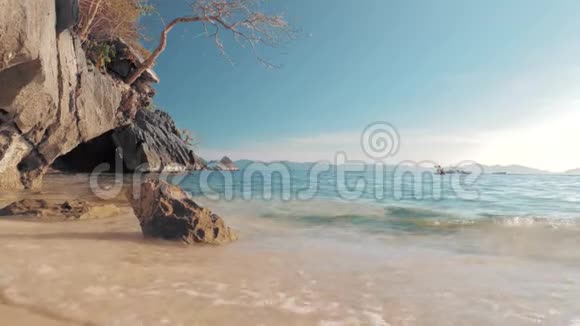 菲律宾巴拉望海景和美丽的海滩沙滩上的岩石阳光明媚的日子里有蓝色的海浪视频的预览图