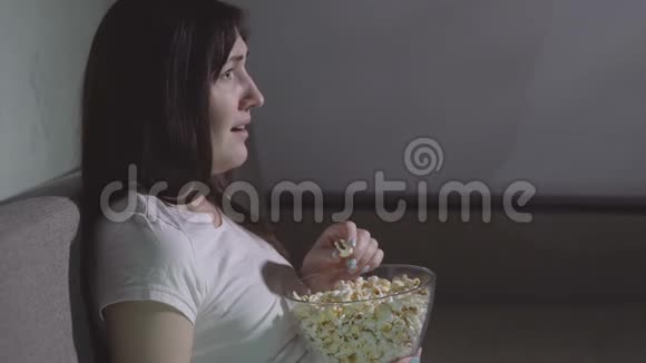 年轻女孩独自一人在看恐怖电影视频的预览图