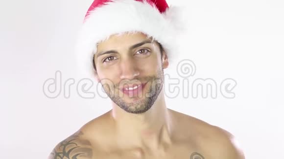 一个年轻的赤膊男模特戴着圣诞帽的肖像视频的预览图
