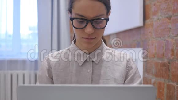 戴头巾的西班牙妇女在笔记本电脑上工作视频的预览图