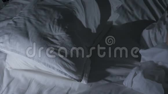 疲惫的女性在夜晚的床上沉睡黑暗的房间视频的预览图