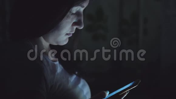 在社交网络中一个晚上坐着电话的年轻女子视频的预览图