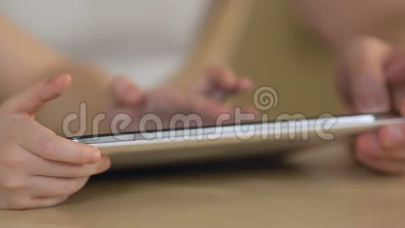 在平板电脑现代技术和童年时代女儿的双手紧紧地打字视频的预览图
