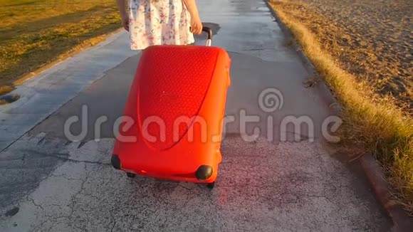 年轻时尚的女人带着红色的手提箱跑假期概念视频的预览图
