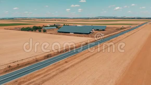 一个小型太阳能电池板农场和道路交通的无人机镜头视频的预览图