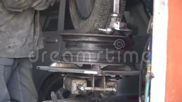 由机械师修理汽车爆胎在换胎器的帮助下从合金车轮上取出轮胎的过程视频的预览图