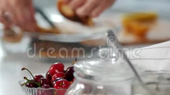 樱桃在一个玻璃碗前的女性手拉出一盘煮熟的煎饼视频的预览图