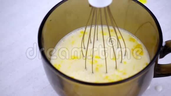 电动搅拌器用牛奶将鸡蛋倒入碗中搅拌工作混合器在缓慢运动视频的预览图