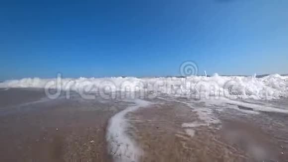 在阳光明媚的夏日海浪覆盖在美丽的沙滩上的摄像机视频的预览图