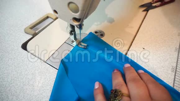 中年妇女手工缝制蓝色织物缝纫机视频的预览图