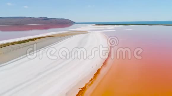 克里米亚的橘子湖射击明亮的橙色湖水与白色沙滩的顶视图外星景观视频的预览图