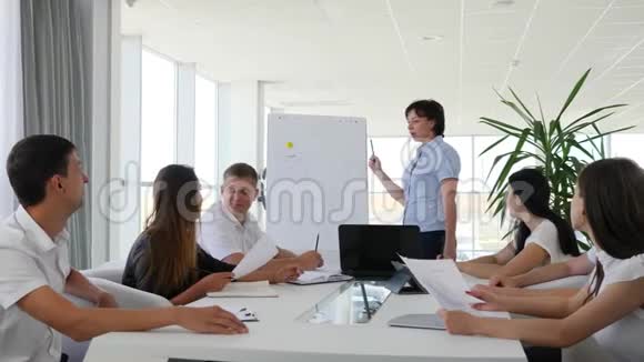 工作人员在现代办公室的大桌子上谈论新的想法商业发展视频的预览图