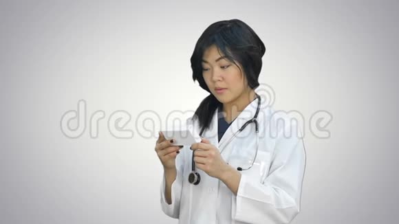 医生女人看着白色背景的一盒药丸视频的预览图
