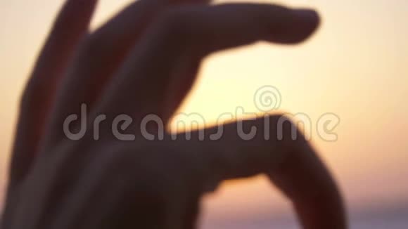 在日落的时候用手势表示符号OK视频的预览图