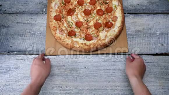 白色桌子背景上木制托盘上的美味披萨框架男人在木制托盘上用意大利辣香肠移动刚出炉的披萨视频的预览图
