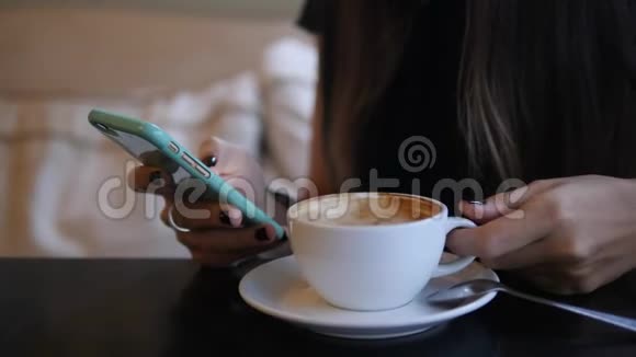 年轻女子在咖啡厅发短信和喝咖啡4K视频的预览图