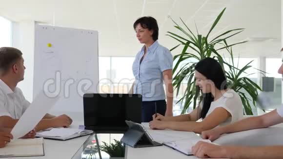 办公室职员在商务中心明亮房间的白板上展示图表视频的预览图