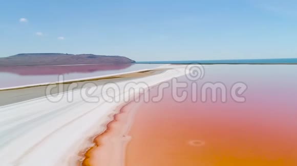 克里米亚的橘子湖射击明亮的橙色湖水与白色沙滩的顶视图外星景观视频的预览图