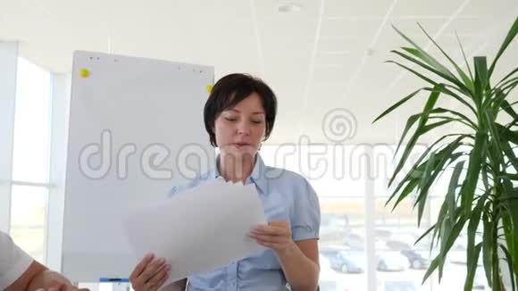 公司主管带纸张为白人办公室的同事分配任务视频的预览图