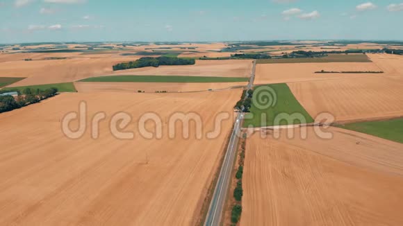 麦地和玉米地之间有汽车的沥青道路的鸟瞰图视频的预览图