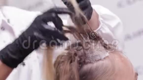 把发型师的手举起来为美容院的一个女人做发型师视频的预览图
