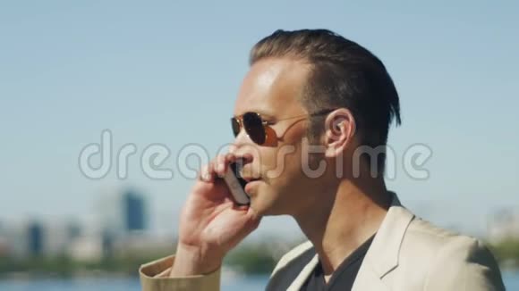一个英俊的男人享受空闲时间在电话里交谈视频的预览图