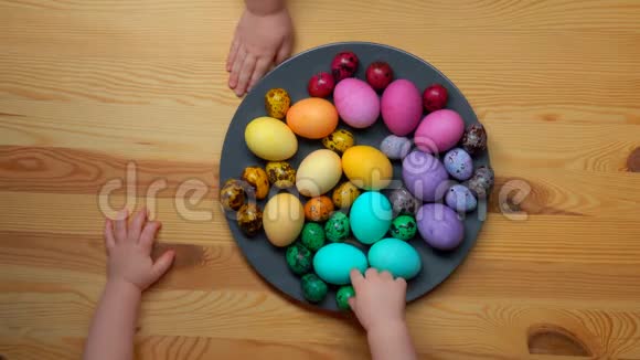 孩子们手从盘子里拿彩色复活节彩蛋视频的预览图