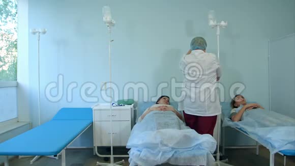 护士戴口罩和手套为病房的女性病人准备点滴视频的预览图