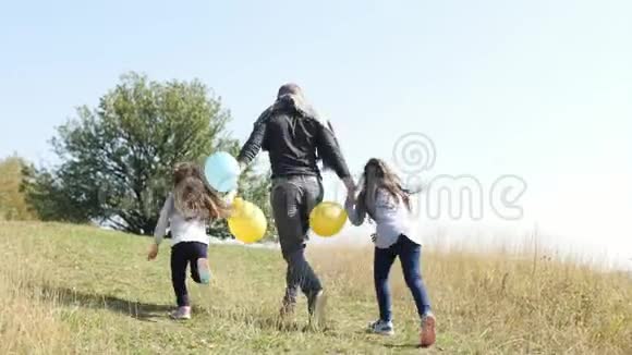 父亲带着两个女儿带着一个气球跑到山上视频的预览图