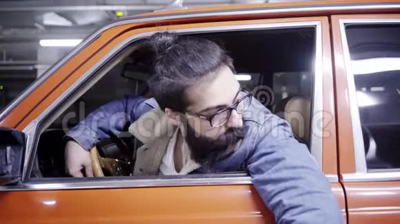 一个留着长发的漂亮胡子家伙看着车窗外开车离开了视频的预览图