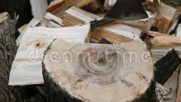 樵夫用斧子砍树干把柴火堆在近景中视频的预览图