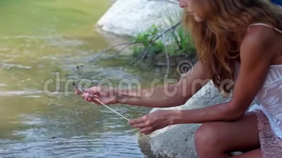 侧景红头发女孩印花虾与棒在河岸视频的预览图