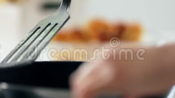 女人的手在煎锅里翻着干酪薄饼视频的预览图